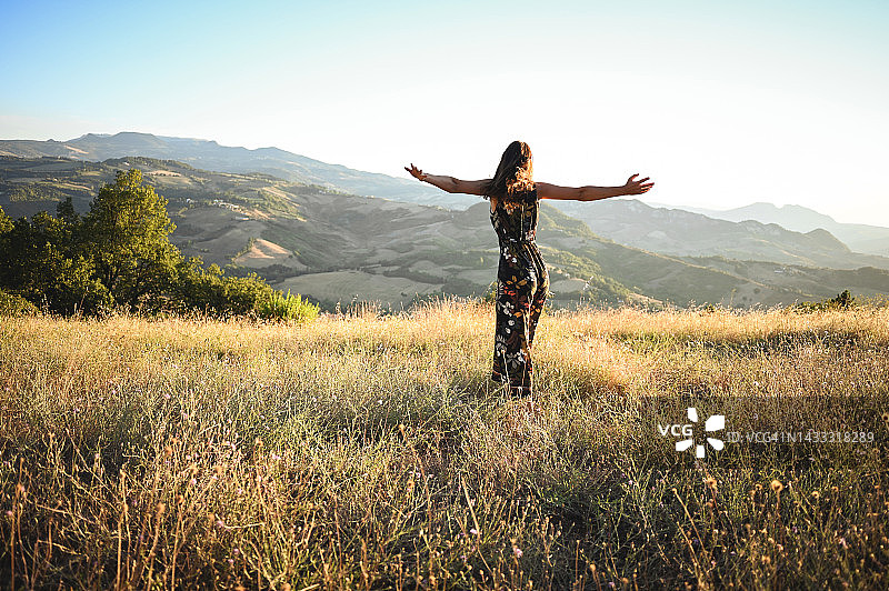 在田园诗般的夏日日落山景中享受图片素材