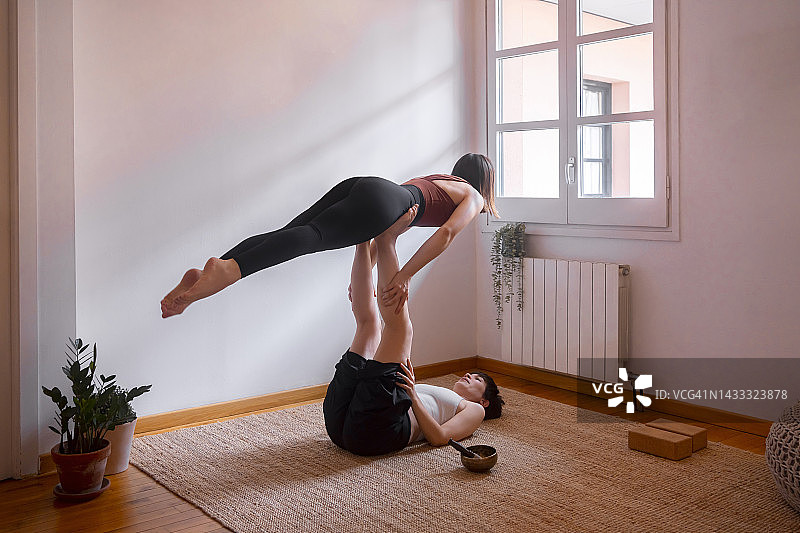 女性在家做双人瑜伽图片素材