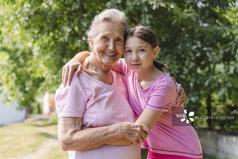 快乐的老年妇女在公园里拥抱孙女图片素材