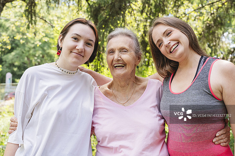 与女儿和孙女一起站在公园里的快乐老年妇女图片素材