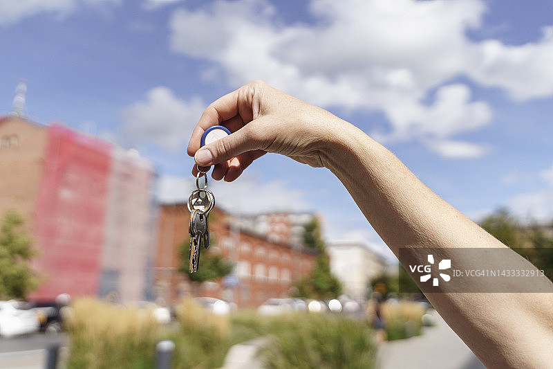 女人在阳光明媚的日子里展示钥匙图片素材