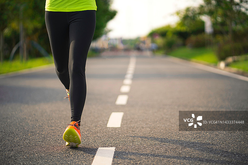 在公园跑步的年轻健身运动女人。健康的健身女人在户外慢跑。运动与健康概念图片素材