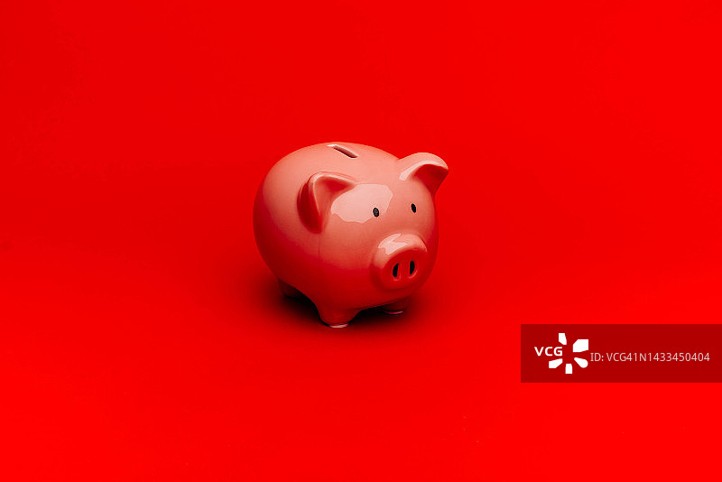 红色背景上的陶瓷储蓄罐图片素材