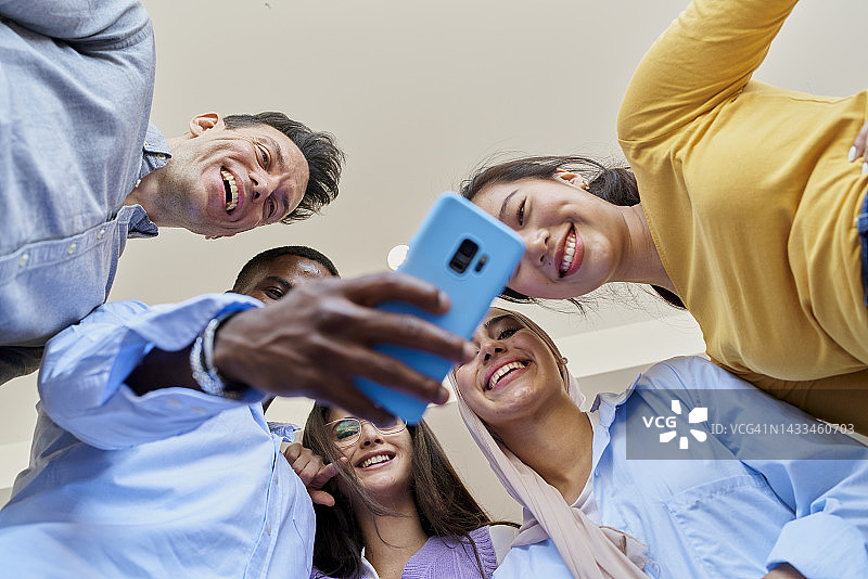 工作后聚在一起用手机看视频的朋友们的欢乐时光图片素材