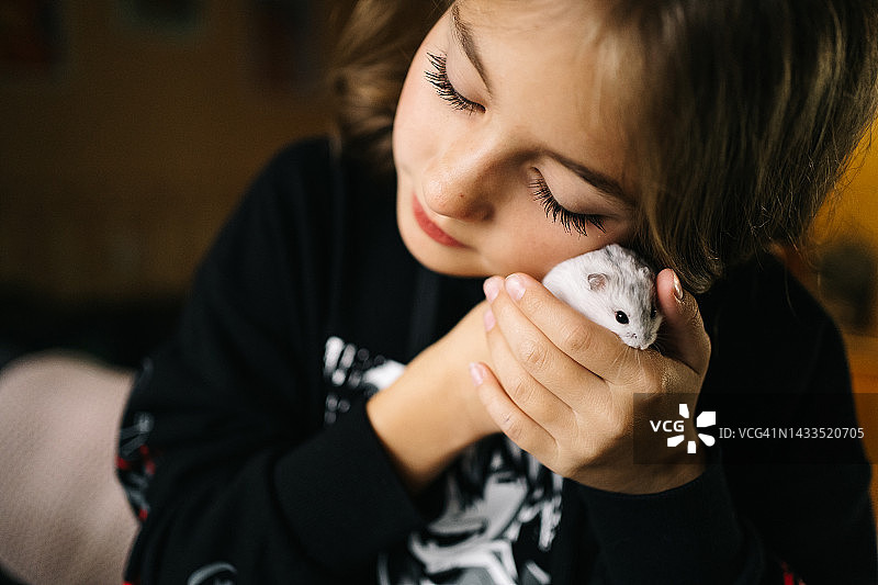 温柔拥抱残疾仓鼠的少女图片素材