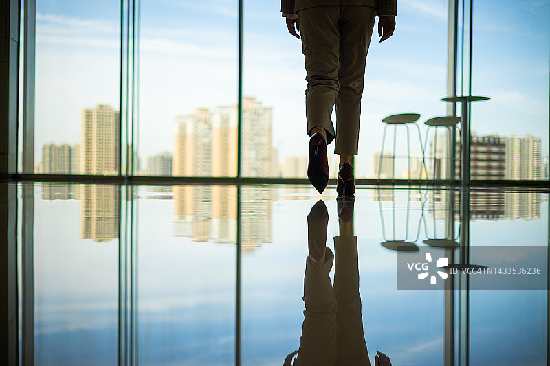 走向玻璃窗的商务女性图片素材