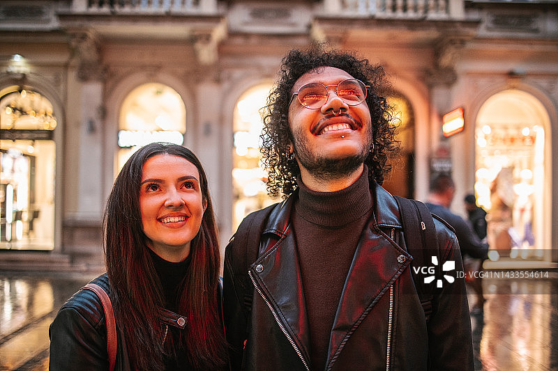 看着被红色霓虹商业标志照亮的商店橱窗图片素材