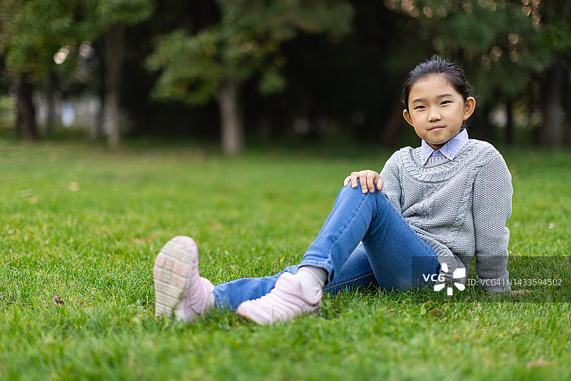 坐在草地上的小女孩图片素材