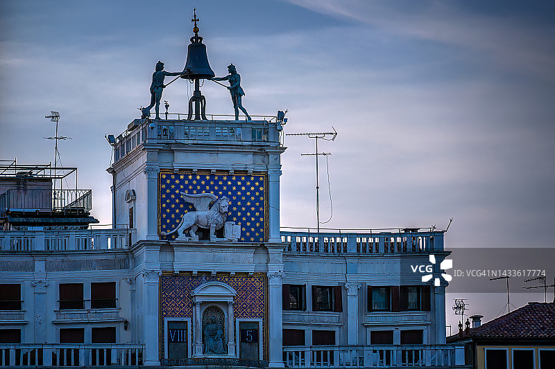 在夕阳的映衬下，敲响圣马可钟楼的两座青铜雕像图片素材
