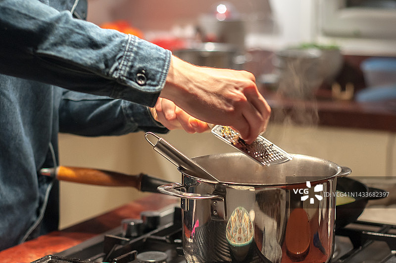 男人手中在锅上擦拭肉豆蔻图片素材