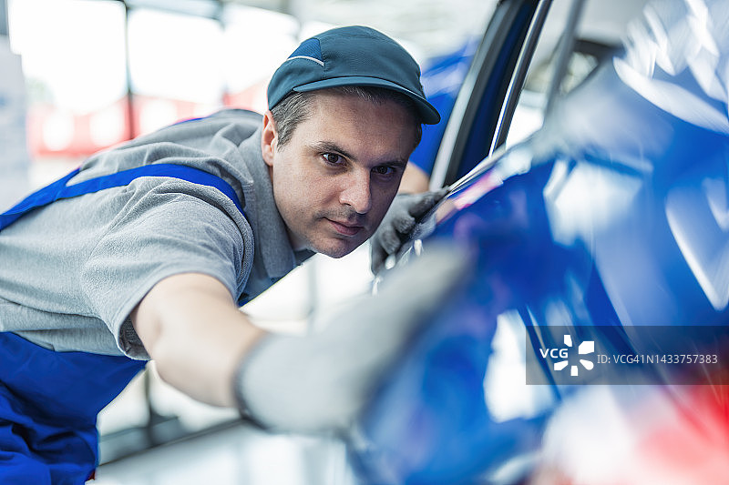 男人用超细纤维布擦拭汽车外部图片素材