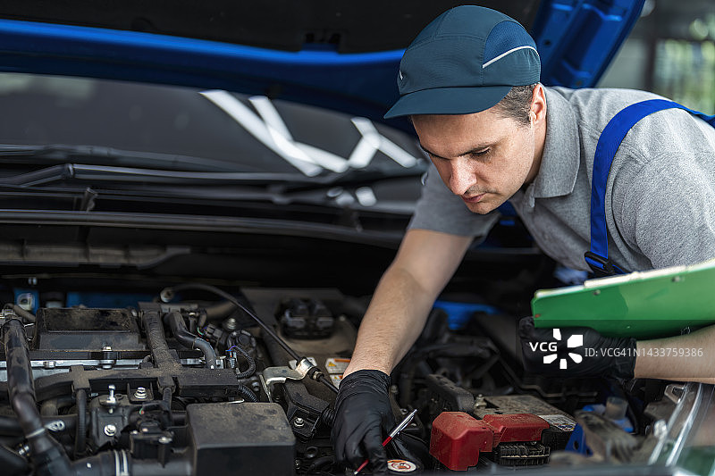 汽车修理工正在进行车辆维护检查图片素材