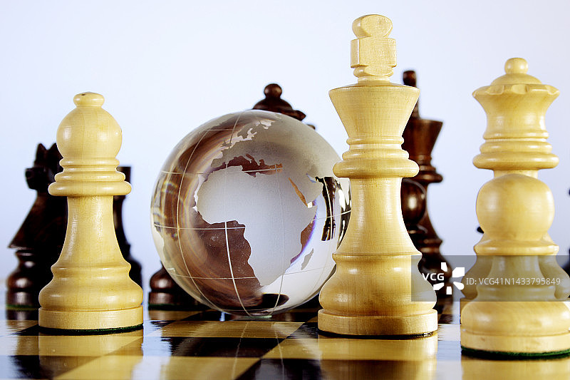 玻璃地球仪和国际象棋棋子特写图片素材