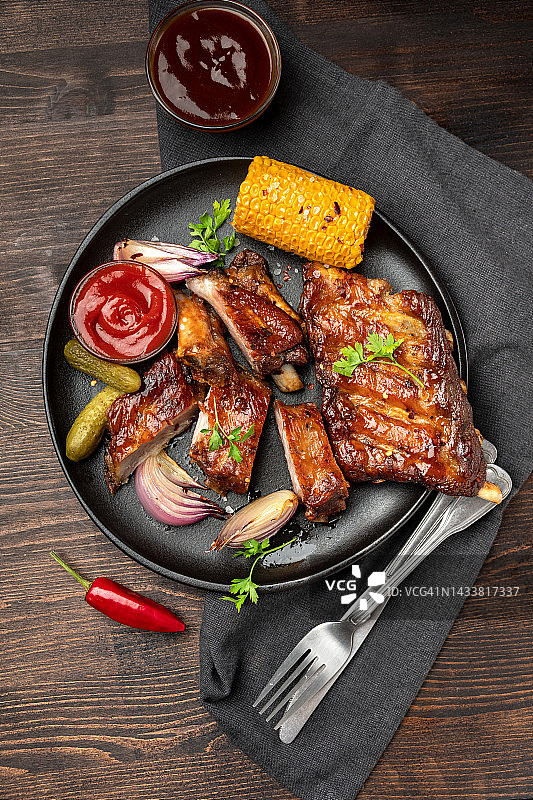 烤排骨配烧烤酱、番茄酱和烤蔬菜图片素材