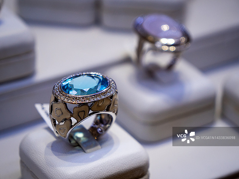 珠宝店中蓝宝石和托帕石戒指的微距特写图片素材