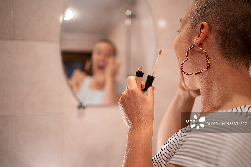 患癌症的光头女子正在化妆的背影图片素材