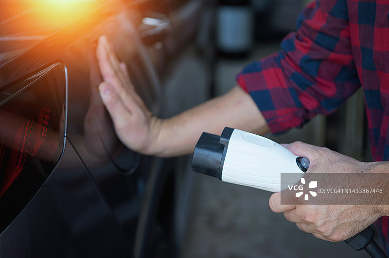 人类手持电动汽车充电枪图片素材