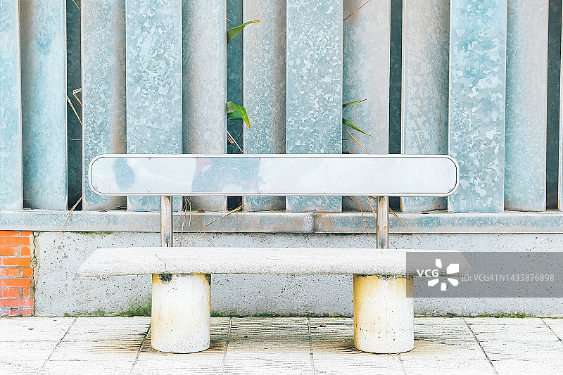 金属板墙边的长椅图片素材