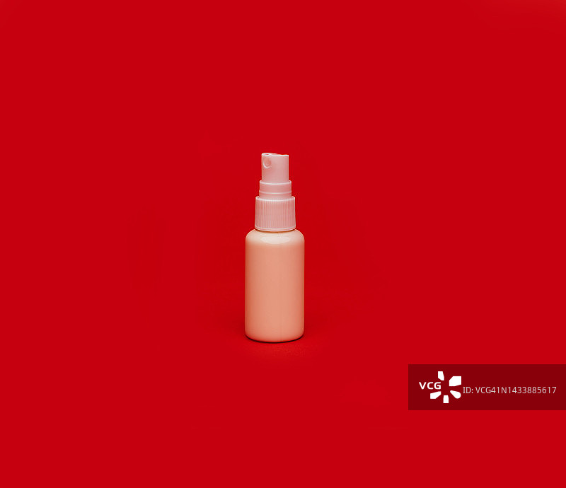 红色背景上的小白喷雾瓶图片素材