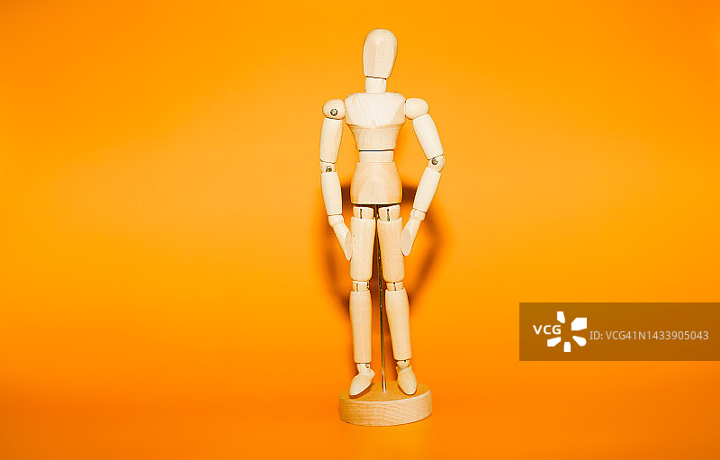 橙色背景下的可弯曲木制小人图片素材