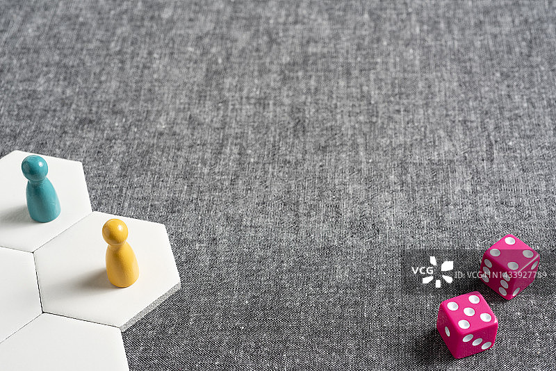 灰色背景一角有两枚米宝在六边形上，另一角有枚粉色骰子图片素材