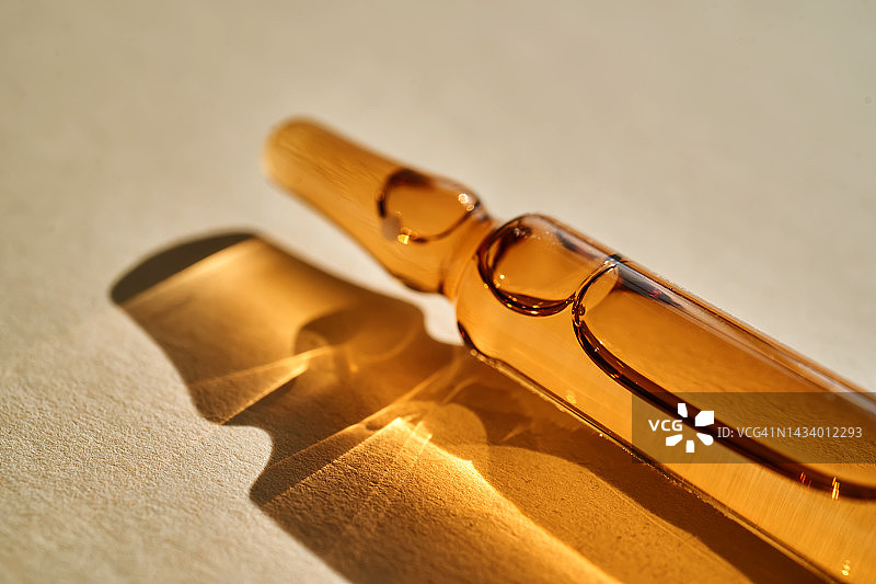 米色背景上的玻璃安瓿图片素材