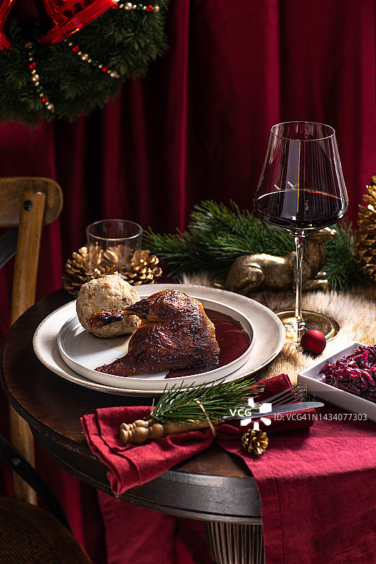 圣诞晚餐：烤鸭、鹅、火鸡配橙子片、红卷心菜和德式饺子图片素材