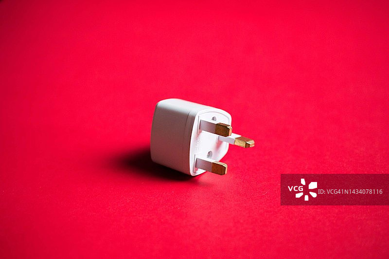 红色背景上的电源适配器金融概念静物图片素材