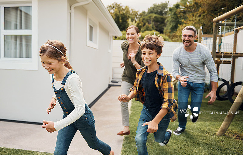 爱，儿童和父母一起玩耍、奔跑、培养感情，在夏季假期、家庭旅行或度假中度过美好时光。快乐的孩子、母亲和父亲支持在后院公园里进行的趣味赛跑游戏图片素材