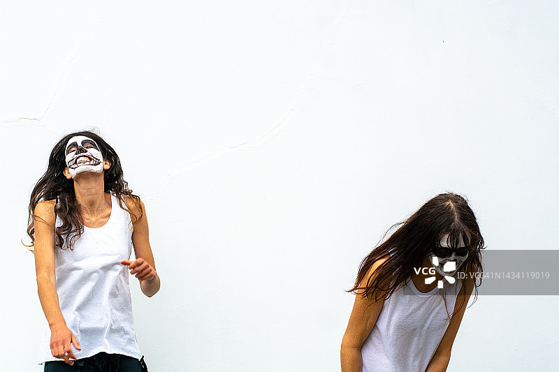 在万圣节家庭派对上跳舞的两个装扮的女人，乐趣，动感图片素材