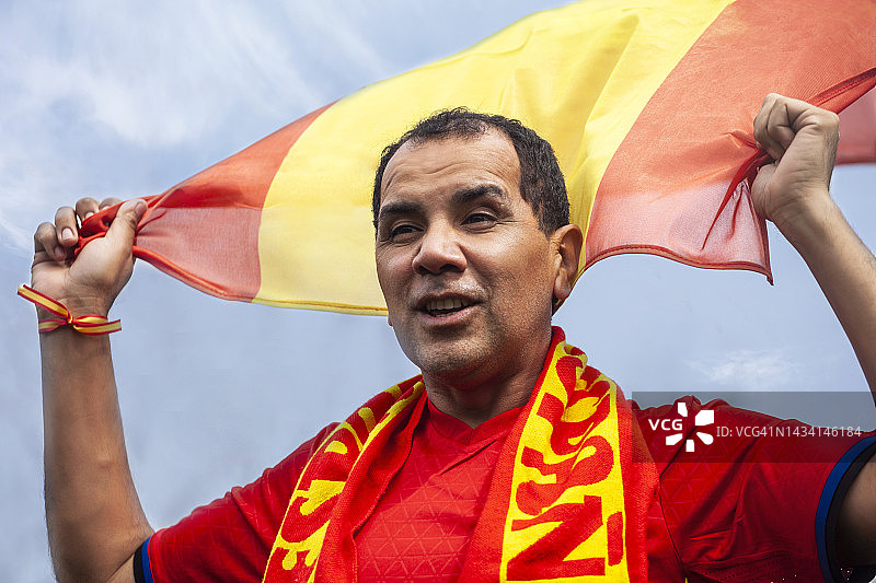 挥舞国旗为国家队欢呼的中年西班牙足球支持者图片素材