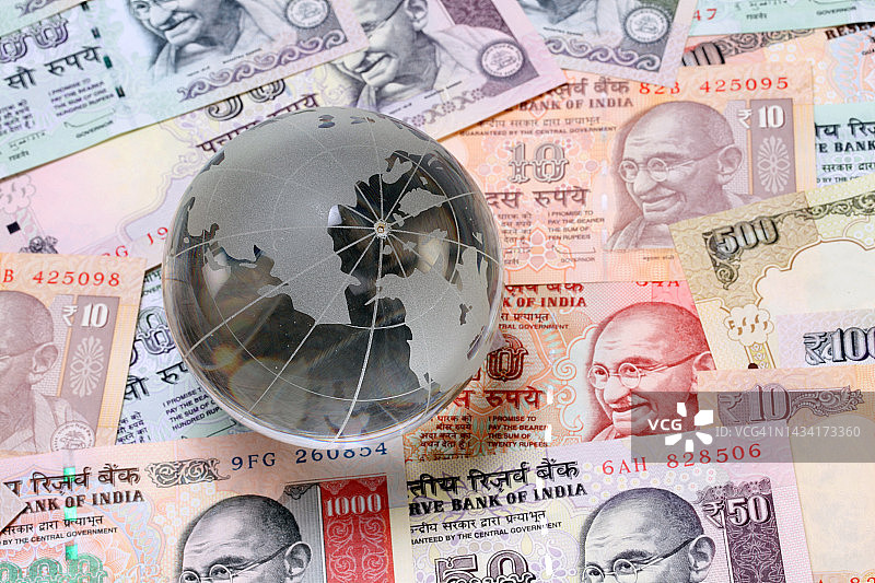 印度货币上的玻璃地球仪图片素材