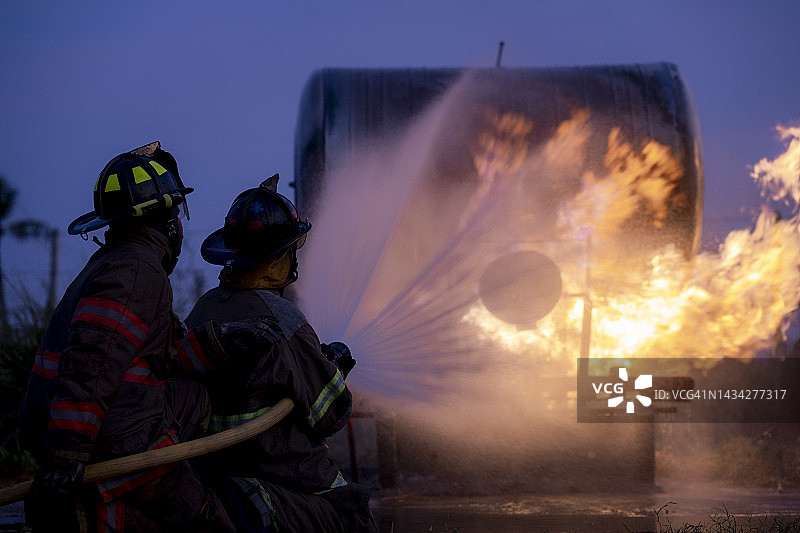 消防员用水管灭火图片素材