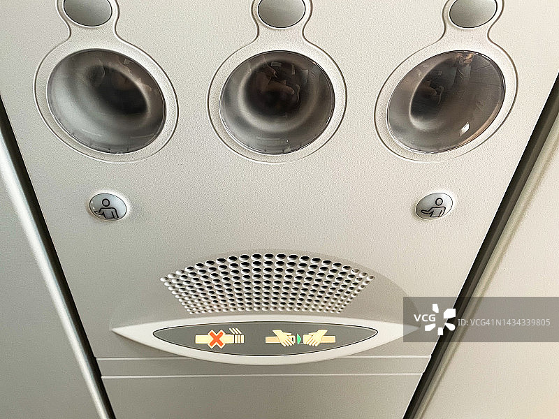 飞行器内灯和风扇控制台超微距特写，带安全带和禁止吸烟标志图片素材