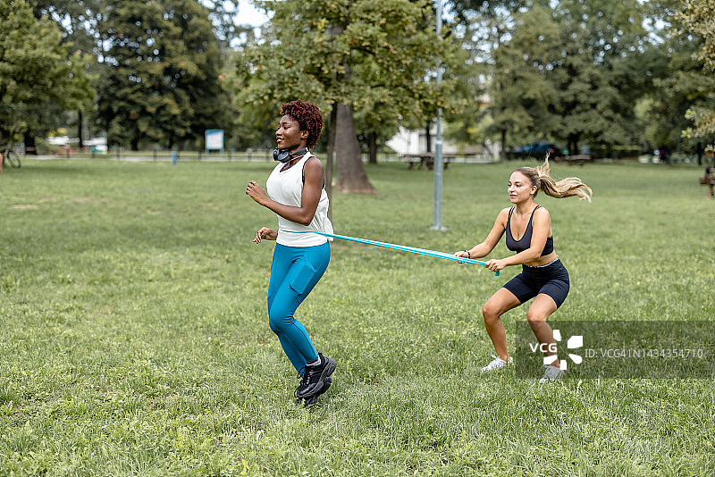 腿上绑着阻力带跑步的女人图片素材