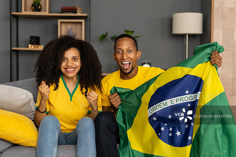 情侣在电视上观看足球比赛图片素材