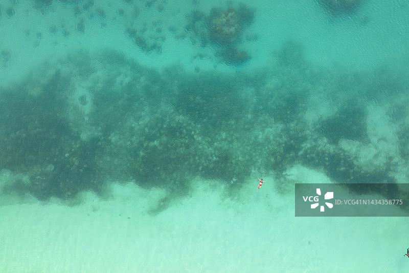 阳光明媚，女孩在桑给巴尔清澈的海水中放松身心，坦桑尼亚，非洲图片素材