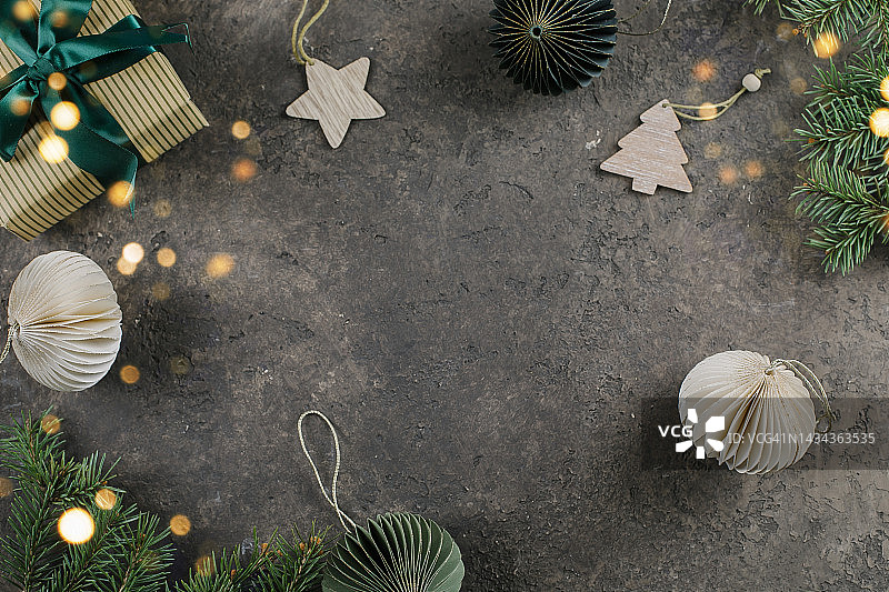 礼品盒、冷杉树枝和米绿色装饰，深色背景。平铺，俯视，复制空间图片素材