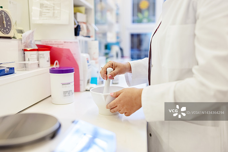 女化学家在药房实验室用研钵研磨药物特写图片素材