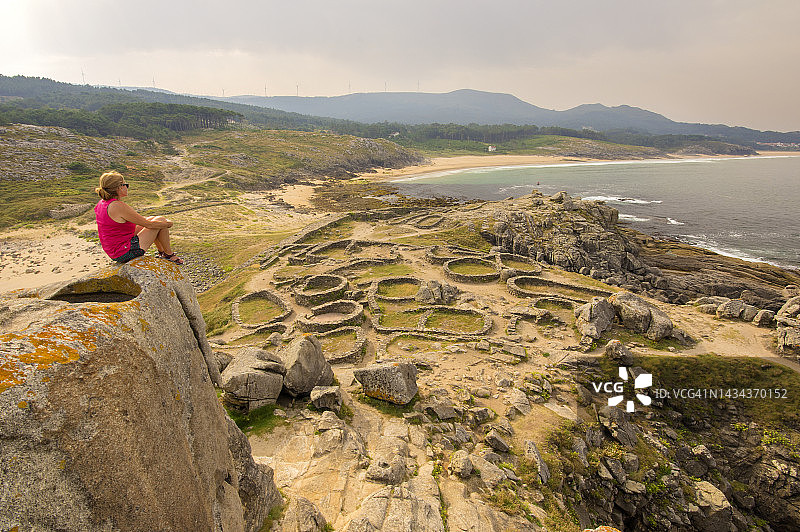 在西班牙加利西亚科鲁尼亚欣赏卡斯特罗巴罗尼亚防御工事遗址的女子图片素材