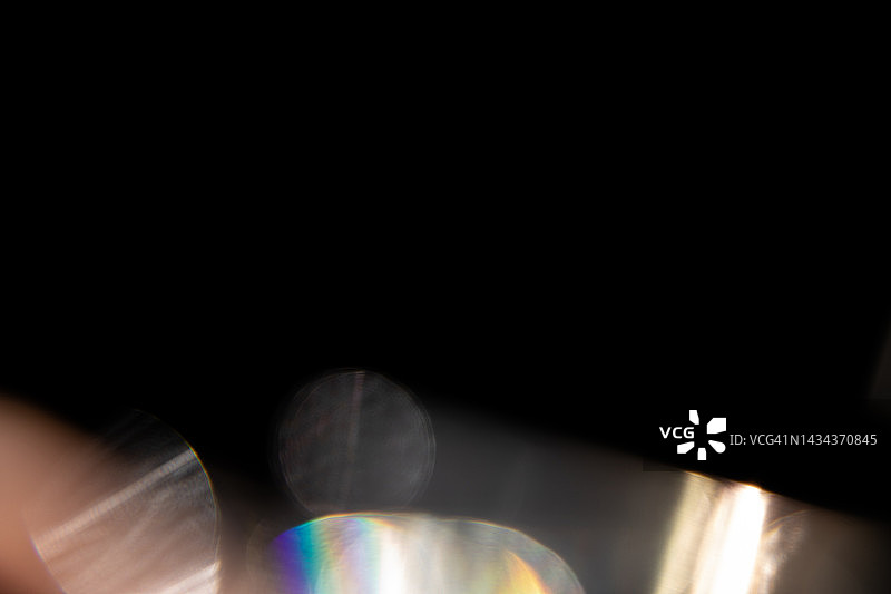 黑色背景上的彩色彩虹漏光纹理图片素材