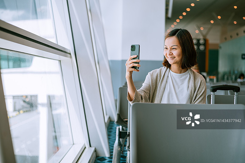 在机场航站楼自拍的亚裔中国女性旅行者图片素材