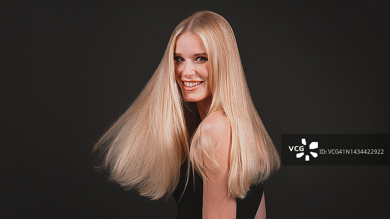 深色背景下风中飘逸金发的女人图片素材