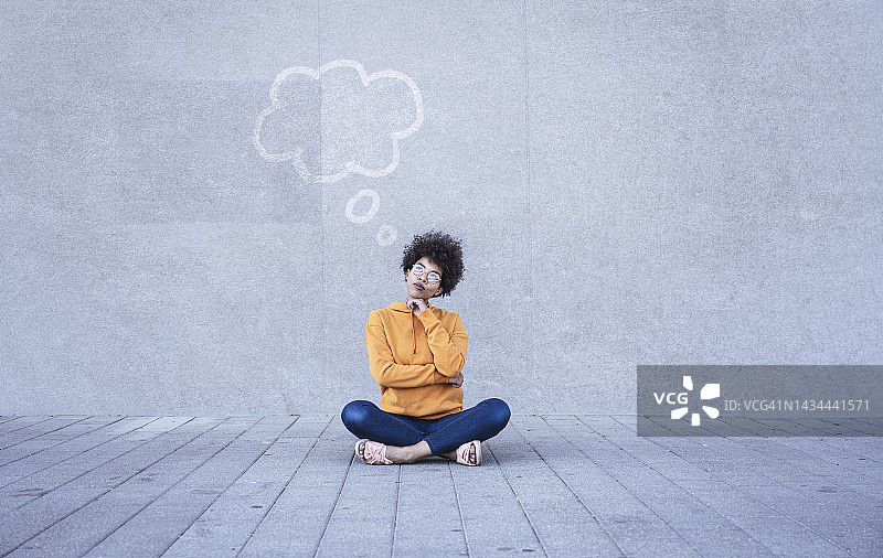 女人盘腿坐在地上，头顶空空的思想泡泡图片素材