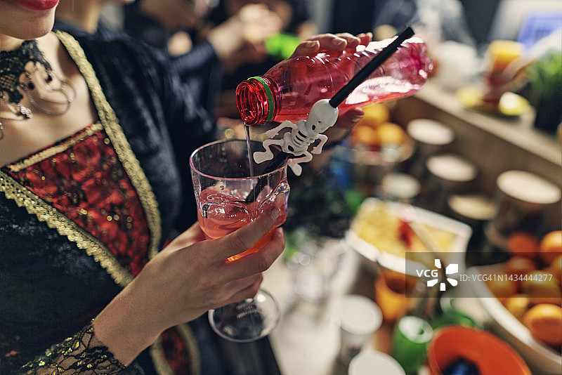 万圣节派对上倒饮料的少女图片素材