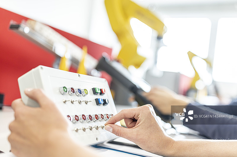 女人在工厂里使用开关盒的手图片素材