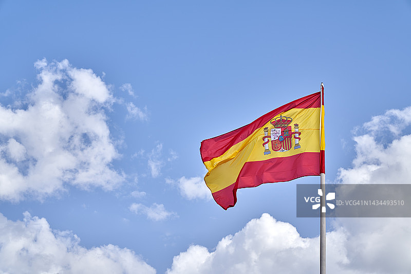 西班牙国旗在蓝天下飘扬图片素材