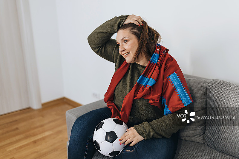 快乐的年轻女人正在观看体育锦标赛图片素材