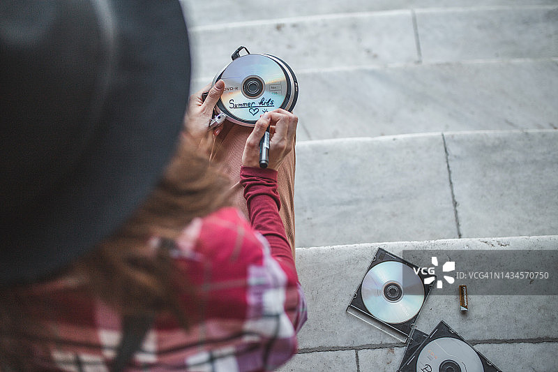 年轻女子用记号笔在光盘上写名字图片素材