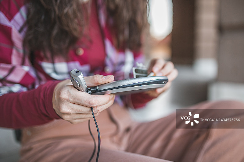 手持迷你光盘播放器的年轻女子双手特写镜头图片素材